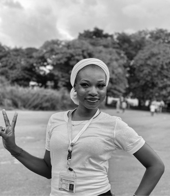 A woman wearing a white headwrap and t-shirt with a "Press" lanyard smiles and flashes a peace sign outdoors in a black-and-white photo. The professional yet casual vibe of the image aligns with her introduction as "Lumi," a Web3 content creator sharing her journey in the crypto space.