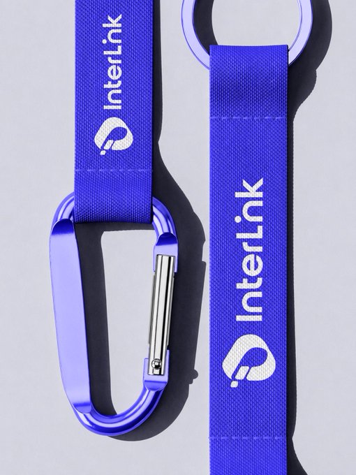 A vibrant blue InterLink lanyard with a matching carabiner clip lies against a white background, displaying the "InterLink" name and logo on its strap, perfectly embodying the "Carry InterLink Wherever You Go" message tied to the #InterLink #ITLG #ITL branding.