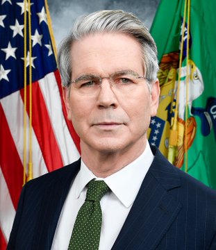 A formal portrait shows an older man with gray hair and glasses wearing a dark suit and green tie, positioned in front of the American flag and a green government flag. The accompanying post speculates that the U.S. government, likely under the leadership of the pictured official (appearing to be a Treasury Secretary), may resort to issuing XRP-based debt rather than implementing a debt jubilee to address fiscal challenges.