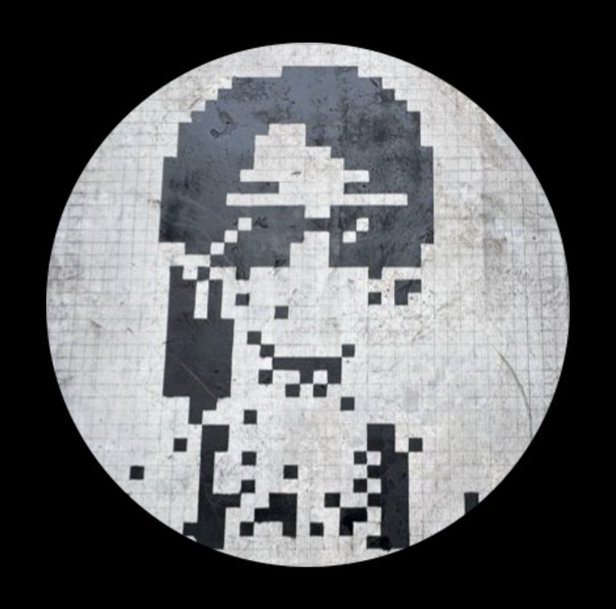 A pixelated, grayscale portrait of a person wearing a hat, displayed in a circular frame on a textured background.