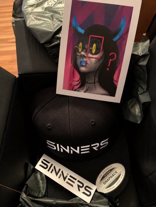 Photo of a black 'SINNERS' branded snapback cap in a box with tissue paper, accompanied by an art print featuring a stylized female character with blue horns.