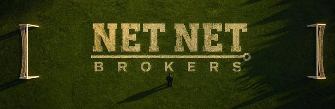 An aerial view of a green field showing 'NET NET BROKERS' spelled out in white material between two goalposts, with a small figure standing in the center.