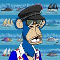 A blue animated monkey character wearing a black hat, sunglasses, and a colorful patterned shirt, set against a tropical beach background with sailboats.