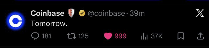 The image shows a social media post from Coinbase, which has a pink heart icon with the number "9989" displayed at the bottom of the post. The post appears to be about an upcoming event or release related to cryptocurrency. The text in the image reads "coinbase Tomorrow", indicating that there is something special happening on the Coinbase platform soon.