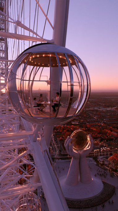 A view of a modern observation tower with a transparent spherical pod containing people, set against a sunset cityscape and a sculptural monument below.