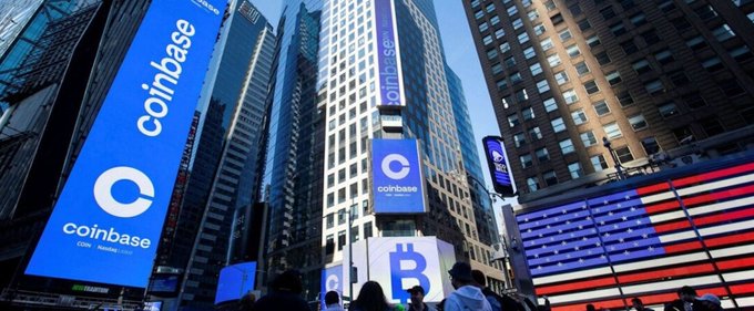 A large blue Coinbase billboard advertisement displays the company logo and 'Coin' text alongside a Bitcoin symbol in what appears to be Times Square.