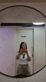 A small, low-resolution circular image showing a blurry figure that appears to be a person in a bathroom or indoor setting.