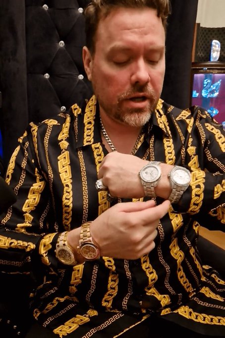 A man in a black-and-gold patterned shirt displays multiple luxury watches, including two silver watches on his wrist and a gold watch below. The image illustrates the post’s cynical remark that the pump.fun campaign is “always” centered on watches.