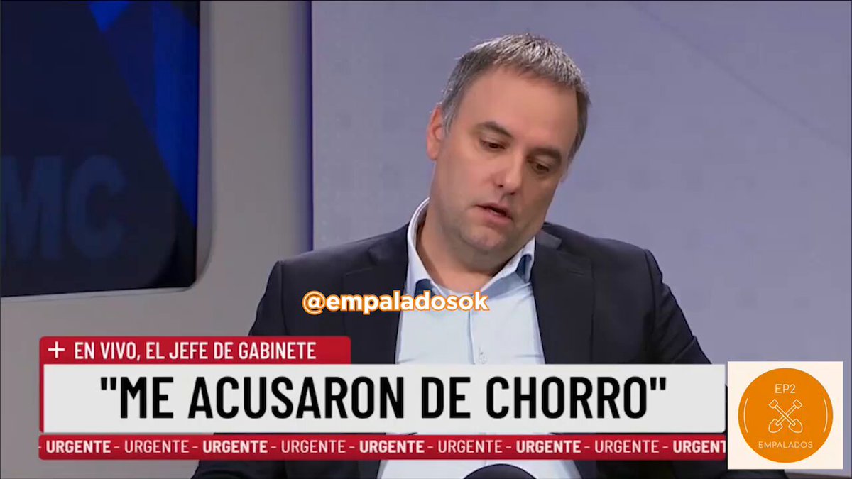 The image features a man dressed in a suit sitting at a desk with his head down while reading something written in Spanish. The text appears to be related to an investigation or legal matter, as indicated by the use of the hashtag #empanada. The man's focused expression and the presence of the Spanish text suggest that he is deeply engaged in understanding or analyzing the content before him.