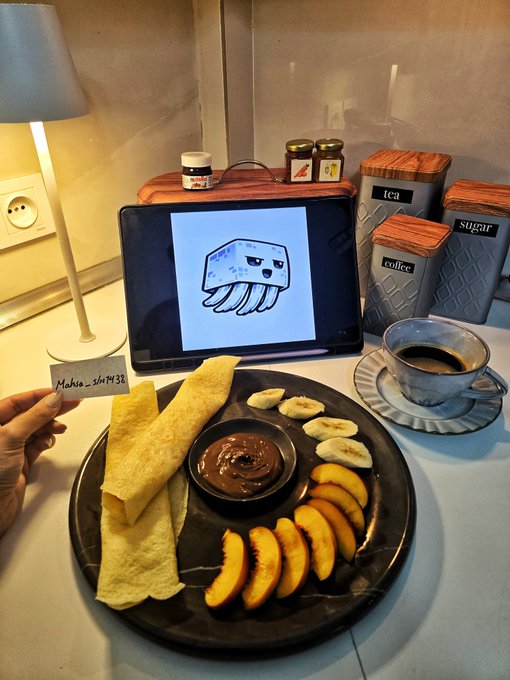 A table setting with a black plate containing crepes, peach slices, banana slices, and a small bowl of chocolate spread, accompanied by a tablet showing a cartoon octopus jellyfish and a cup of coffee.