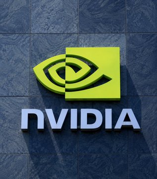 The image shows the NVIDIA logo (the distinctive green eye emblem and "NVIDIA" wordmark) mounted on a dark stone wall. It relates to the news as it represents NVIDIA, the company whose AI hardware and architecture SpaceX will exclusively adopt for its satellite-based "Starmind" space data center launching in 2027.