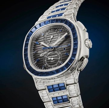 A luxurious Patek Philippe Nautilus-style watch featuring a stainless steel bracelet with baguette-set diamonds and blue sapphires, a matching blue sapphire-set bezel, and a textured grey dial with chronograph sub-dials, priced between $2–3 million for ultra VVIP clientele.