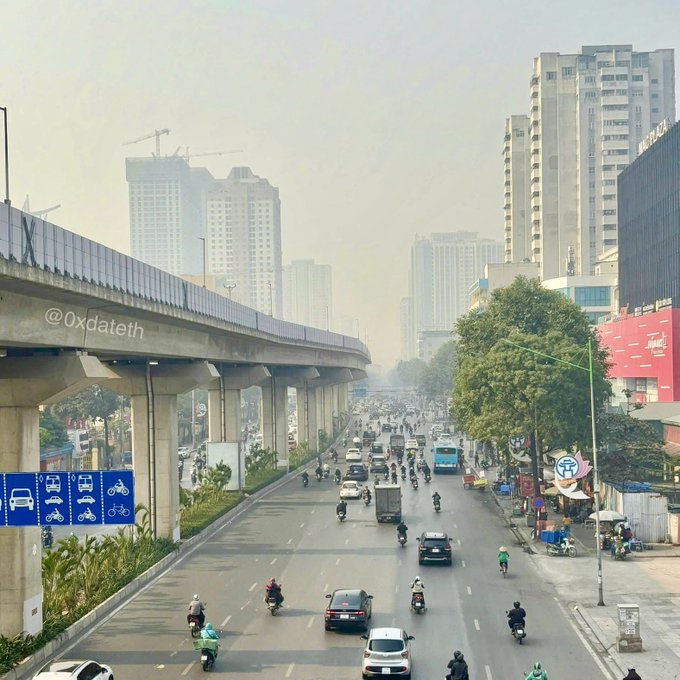 A hazy urban cityscape featuring an elevated metro/train line with traffic on the road below, watermark '@0xdateth' visible.