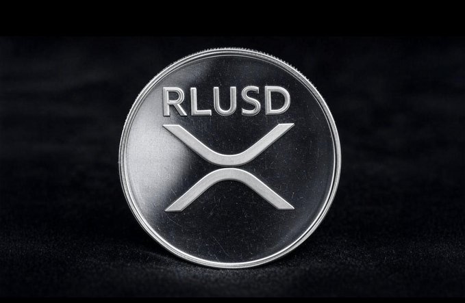 A silver physical coin featuring the 'RLUSD' ticker and the XRP (Ripple) logo, photographed against a dark background.