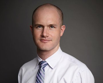A professional headshot of a bald man wearing a white dress shirt and a blue striped tie, smiling slightly at the camera against a dark gray background. The image accompanies a quote attributed to Coinbase CEO Brian Armstrong, suggesting the man is Armstrong himself.