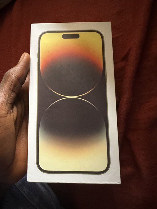 A hand proudly holds a sealed iPhone 14 Pro box, likely representing the "big boy purchase" mentioned in the post. The image ties into a Web3-related achievement or milestone being celebrated by the user.