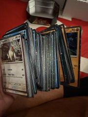 A hand holds a thick stack of Pokémon trading cards, including a holo Cosmic Eclipse card (number 92) on top, confirming the "stack of cosmos holos" guess from the post.