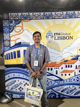 A man standing and smiling in front of an 'ETHGlobal LISBON' event backdrop decorated with traditional Portuguese azulejo tile designs.