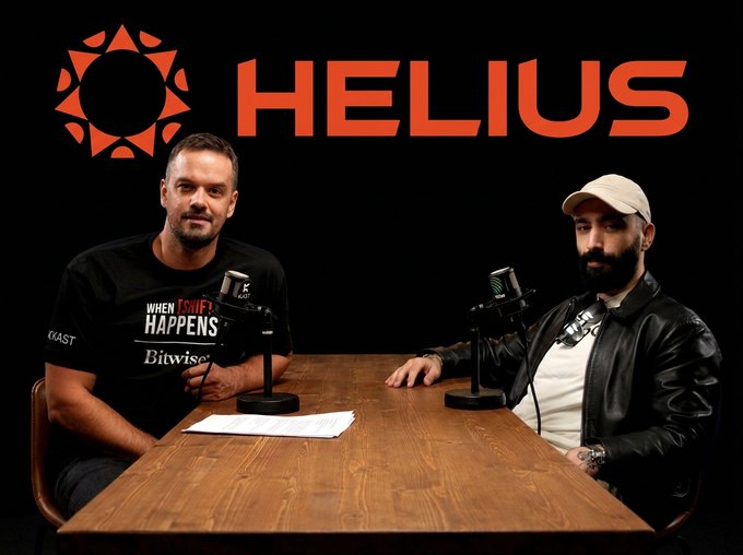 Two men sit at a wooden table with microphones in front of a black backdrop featuring the red "HELIUS" logo and sun emblem, recording an episode of the "When Shift Happens" podcast featuring Bitwise branding on the host's shirt.