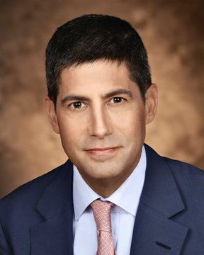 The image features a man dressed in a suit and tie, with his face clearly visible against a brown background. The caption below the photo reads "Federal Reserve Chair Kevin Warsh says, 'if you're under 40, Bitcoin is your new gold.'". This statement suggests that the man might be discussing the current state of cryptocurrency or its potential impact on younger generations.

The image also includes other text elements such as a pink tie and the words "Bitcoin" and "under 40", which further emphasize the connection between the man's appearance in the photo and his statement about Bitcoin.
