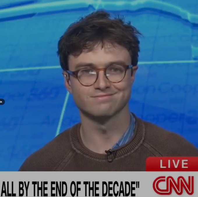 A young man with round glasses appears on a CNN live broadcast, with the lower-third chyron reading 'ALL BY THE END OF THE DECADE.'
