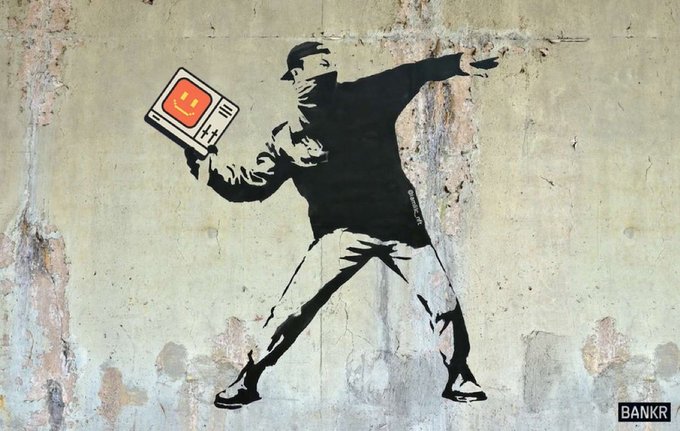 A stencil-style street art mural resembling Banksy's 'Flower Thrower', showing a masked figure throwing a laptop with a smiley face instead of a bouquet, branded with 'BANKR' in the corner.