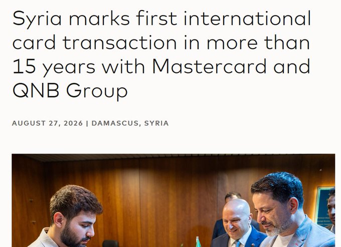 A news headline reading 'Syria marks first international card transaction in more than 15 years with Mastercard and QNB Group', dated August 27, 2026, Damascus, Syria.