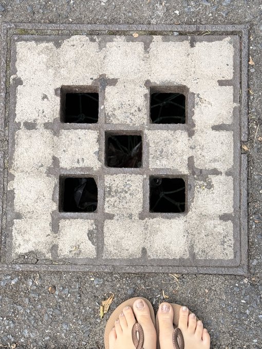 The image features a person's feet standing next to a square concrete block with six holes, which appears to be part of an underground drainage system or sewer grate. The person's feet are positioned at the bottom right corner of the image, while their toes are visible on the left side. In the background, there is text that reads "OKX'S territory expansion is really huge Even sponsoring roads @okxchinese". This suggests that the drainage system might be located in a city or urban area where infrastructure projects like road construction and drainage systems are being implemented.

The image also contains some text about the person's feet, which could be an artistic or humorous statement related to their situation. The combination of these elements creates an interesting juxtaposition between the human body and the urban environment represented by the drainage system.