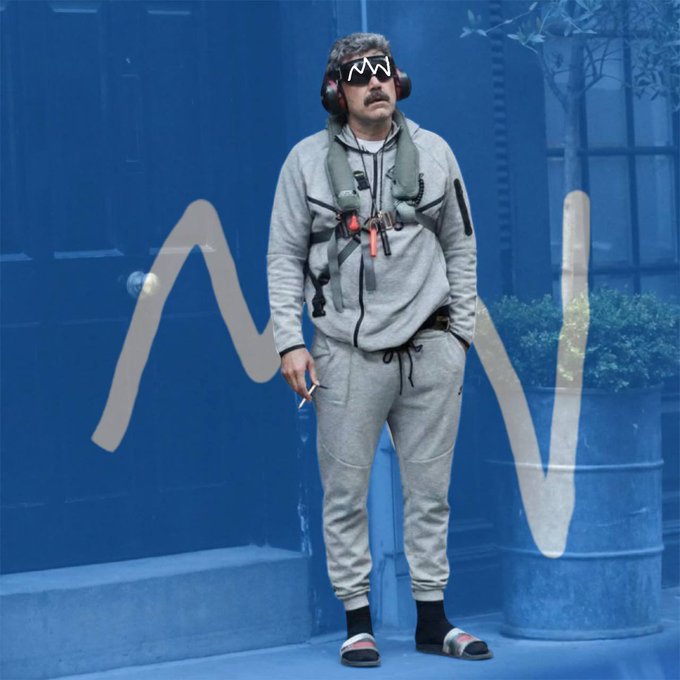A man in a gray tracksuit, headphones, and sunglasses leans against a blue wall while smoking a cigarette, with an exaggerated audio waveform graphic overlaid.