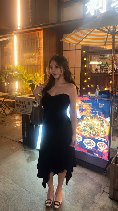 A young woman in a black strapless dress and heels stands outside a vibrant food stall at night, with a menu board featuring dishes and a sign with Japanese text visible nearby. The image creates a striking contrast with the crypto-focused post, juxtaposing a stylish nightlife scene against a casual list of tokens (btc, hype, ena, eth, zec, sol) as if playfully suggesting the real "alpha" worth chasing.