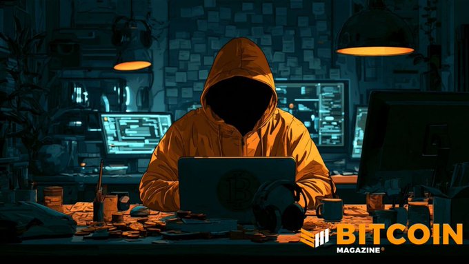 A hooded, faceless person sits at a cluttered desk working on a laptop in front of multiple screens with code, surrounded by stacks of coins. The image features the "Bitcoin Magazine" logo and a Bitcoin symbol, visually reinforcing the post's theme of a scammer who allegedly stole money only to have nearly $5 million in Bitcoin stolen from their own Ledger wallets by other thieves.