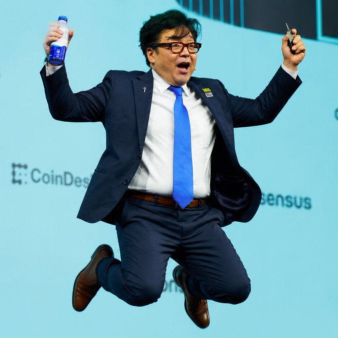 Tom Lee, chairman of BitMine (ticker: BMNR), leaps in the air in celebration while holding up a beverage, as the backdrop of the CoinDesk Consensus conference aligns with the company's headline-grabbing accumulation of 28,086 ETH (~$70M), bringing its total holdings to 5,929,198 ETH—approximately 4.9% of Ethereum's circulating supply, valued at ~$14.8B.
