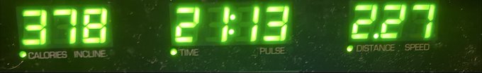 A green LED display from exercise equipment showing 378 calories/incline, a time of 21:13, pulse, and distance/speed of 2.27.
