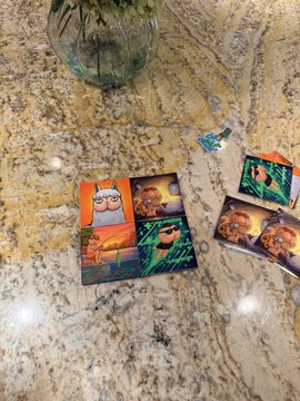 Two wrapped gifts featuring cartoon llama and alpaca designs with tropical/orange backgrounds lie on a granite countertop, possibly containing chocolate or candy treats.