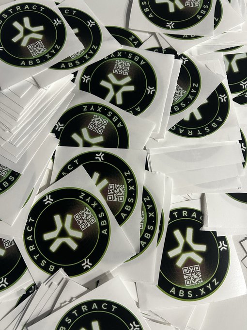 The image features a large pile of white stickers with black text and logos. The stickers are arranged in various sizes and orientations, creating an interesting visual effect. The text "Abstract Chain" can be seen throughout the image, indicating that these stickers may have some connection or association with Abstract Chain ES. The post also mentions that there is a team behind the scenes working on exciting projects, which could imply that the stickers are related to a specific project or event.

The image does not provide any additional information about the content of the stickers or their purpose.