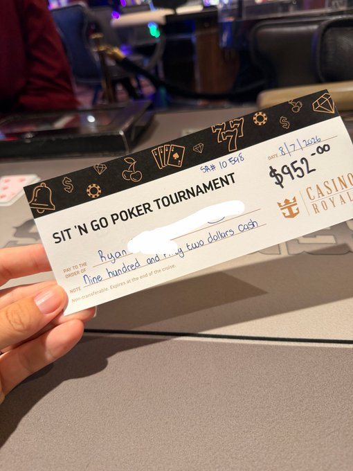 A hand holding a winning poker tournament ticket from Casino Royale for a Sit 'N Go Poker Tournament with $952.00 cash prize, written out as 'nine hundred and fifty two dollars cash' in blue ink.
