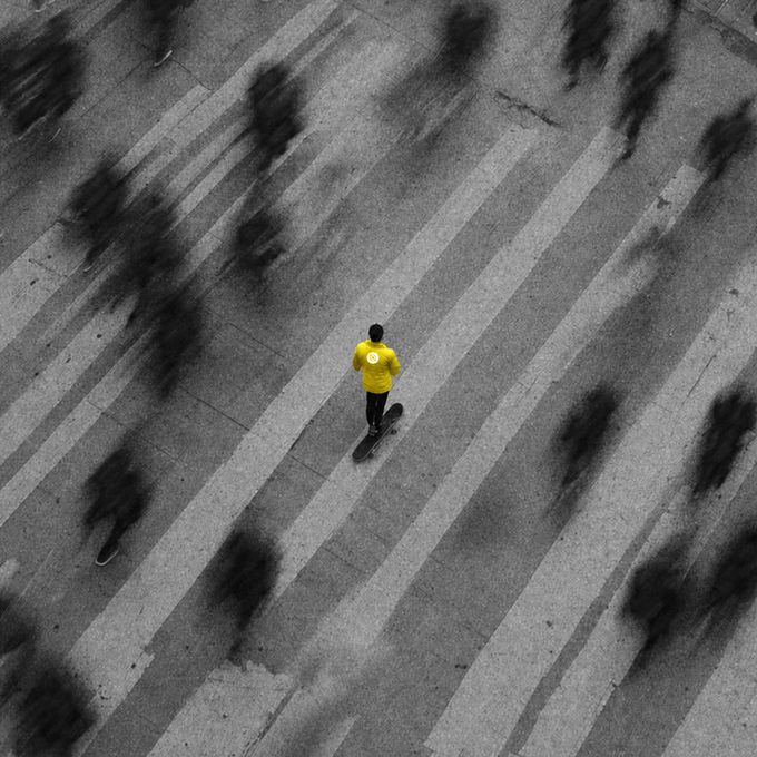 A lone skateboarder in a bright yellow shirt glides through a crosswalk, standing out sharply against the blurred, grayscale motion of the surrounding crowd.

The image visually echoes the post's message of "Building on Abey sets you apart from the crowd"—just as the vivid yellow rider distinguishes himself from the monochrome figures around him, the post suggests that the platform helps users stand out distinctly from their peers.