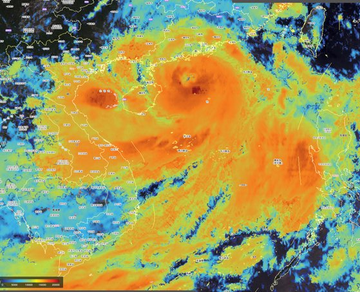 A weather satellite or radar map shows a large swirling storm system with intense orange and red coloration indicating heavy precipitation, with geographic outlines visible underneath the storm data.