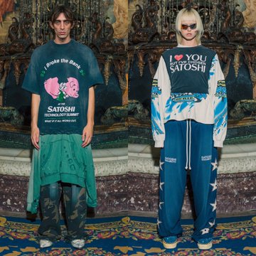 Two models pose in a baroque interior wearing coordinated streetwear from the Satoshi Nakamoto FW26 collection, featuring graphic tees and hoodies printed with "I Froze the First Block" and "I ❤️ YOU SATOSHI," paired with distressed denim, combat boots, and utility skirts that lean into the brand's signature crypto-meets-grunge aesthetic.