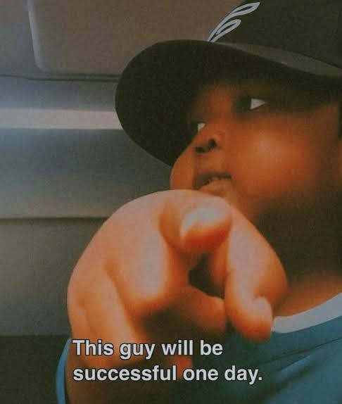 A meme image shows a child in a dark cap pointing directly at the camera, with the caption 'This guy will be successful one day.'