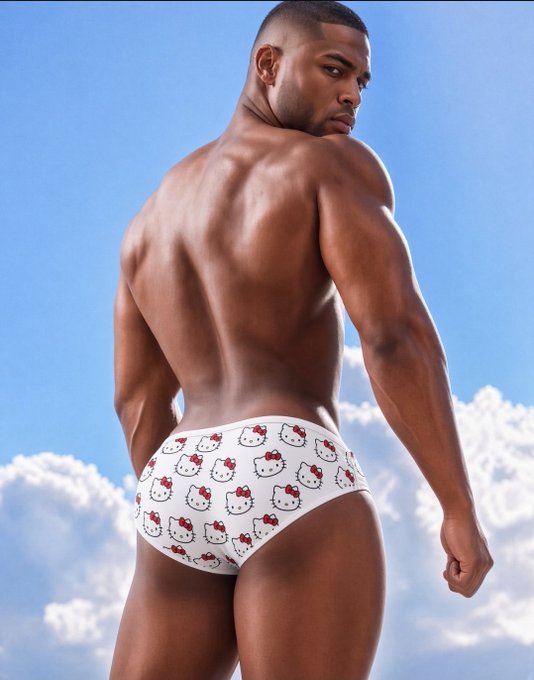 A photograph of a muscular Black man posing with his back to the camera against a blue sky with white clouds, wearing white briefs patterned with Hello Kitty designs.