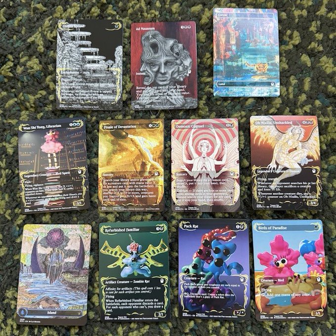 A collection of Magic: The Gathering cards arranged on a green carpet, including cards like Ad Nauseam, Path of the Deep, Liberation, Oh Nixilis, Unshackled, and Pack Rat.