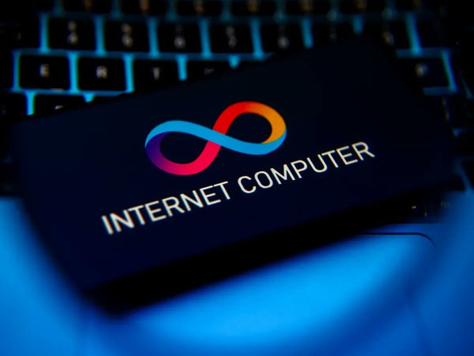 The image features a laptop computer with an open lid displaying the Internet Computer logo. The laptop's screen shows that the word "ICP" is visible as well. The background of the image is dark, which contrasts with the bright colors used for the Internet Computer logo and makes it stand out more prominently.