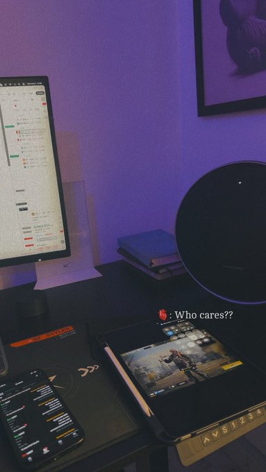 The image shows a desk with various electronic devices, including a computer monitor, keyboard, mouse, cell phone, and a book. The desk also has a small black speaker placed next to the computer monitor. A poster can be seen on the wall behind the desk, which is related to the post about campaign farming that was shared in the image.