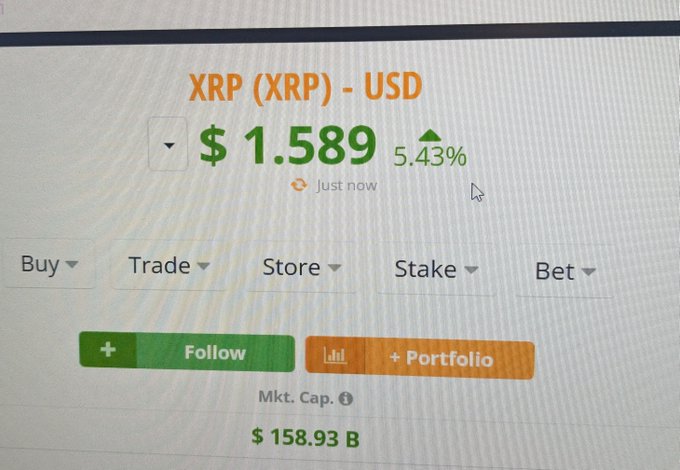 A computer screen displaying the cryptocurrency XRP (XRP) - USD trading at $1.589 with a 5.43% increase.