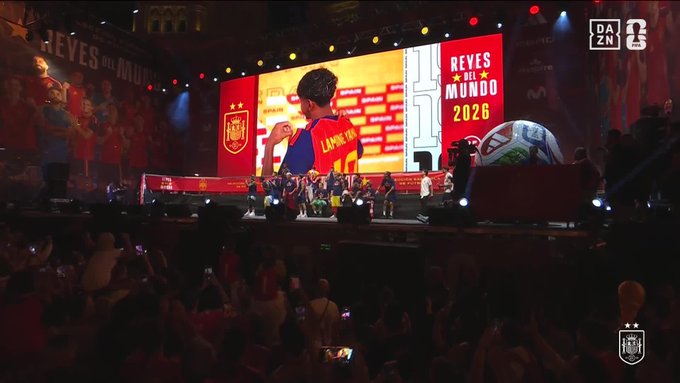 A stage event titled "REYES DEL MUNDO 2026" features a soccer player on a large screen with "LAMINE YAMAL" and a Spanish national team logo visible, while the DAZN logo appears in the top right corner, tying into the post's "AURA" theme by showcasing the rising star's celebrated aura on a grand promotional platform.