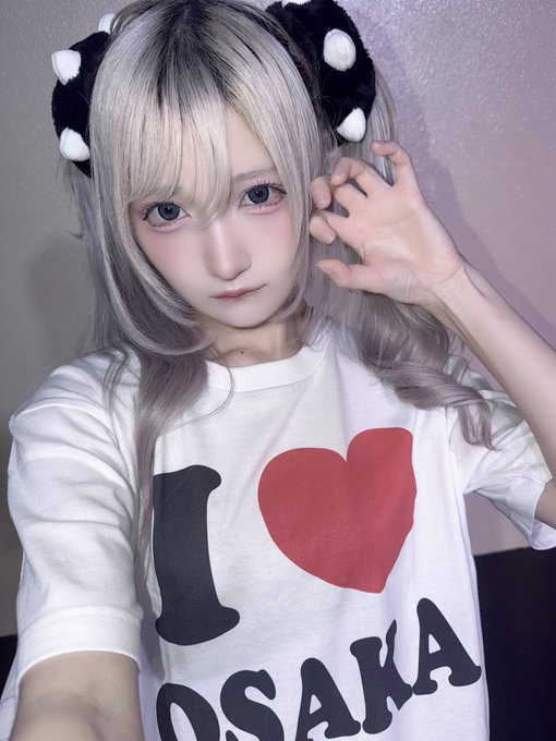 A person with silver hair wearing black-and-white spotted fuzzy paw accessories poses for a photo in a white t-shirt that reads "I ❤️ OSAKA" in bold black and red lettering.