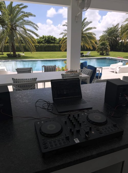A DJ setup with controllers and a laptop overlooks a tropical pool area with palm trees, paired with a caption celebrating "$SOL" trading at "1.6" and inviting viewers to "Just hit the like and say gm"—suggesting a casual crypto market update shared from a resort-style backdrop.