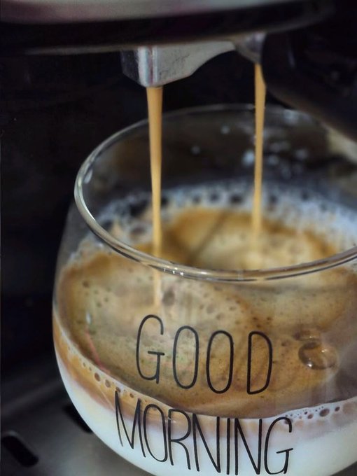 Espresso being poured into a clear glass cup with "GOOD MORNING" text, creating a frothy brown beverage.