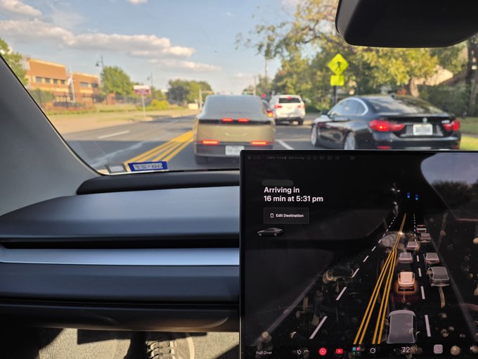 The image shows the interior of a Tesla Cybercab with a large center touchscreen displaying a 3D visualization of surrounding vehicles, including another Cybercab directly behind it. The screen also displays navigation text reading “Arriving in 16 min at 5:31 pm” and an “Edit Destination” button, matching the post’s humorous idea about the display recognizing the Cybercab behind it.